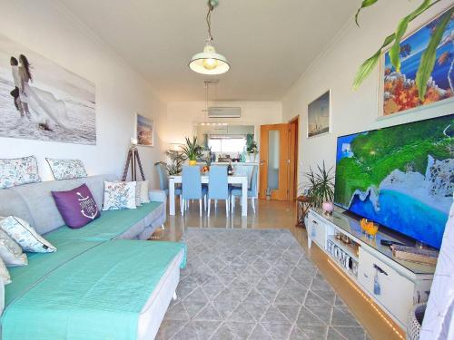 een woonkamer met een bank en een flatscreen-tv bij AlbufeiraOrada II by Be Cherish in Páteo