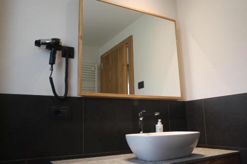 a bathroom with a white sink and a mirror at Oltre Alpine Hotel in Bormio