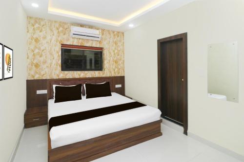 a bedroom with a bed and a tv on the wall at Hotel O Kabir Residency in Rānchī