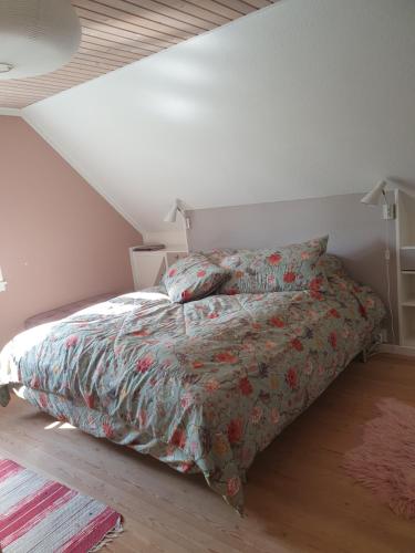 a bedroom with a bed with a comforter on it at Pegasus Bed & Breakfast in Hillerød