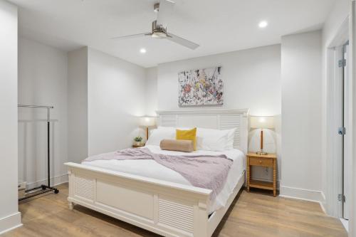 a white bedroom with a white bed with yellow pillows at The Eleanor New Orleans in New Orleans
