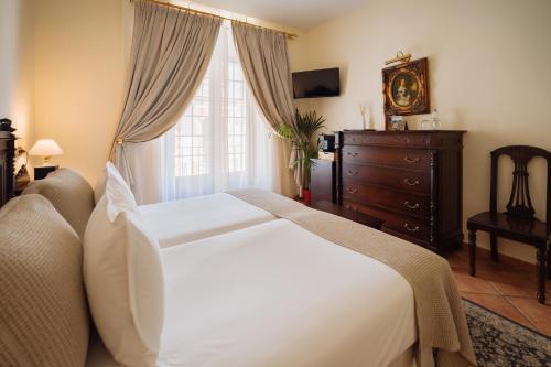 a bedroom with a large white bed and a window at Hotel Palacio de Hemingway in Ronda