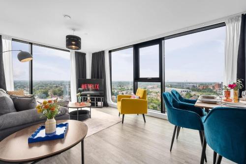 a living room with a couch and chairs and windows at Skyline Old Trafford flat by City SuperHost in Manchester