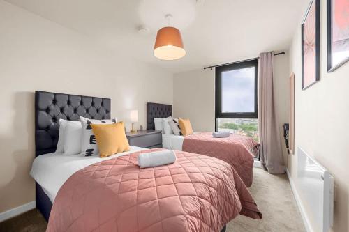a bedroom with two beds and a window at Skyline Old Trafford flat by City SuperHost in Manchester