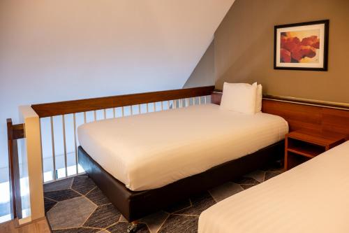 a bedroom with two beds and a balcony at Crowne Plaza Maastricht by IHG in Maastricht