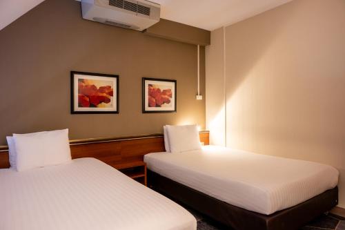 a hotel room with two beds and a tv at Crowne Plaza Maastricht by IHG in Maastricht