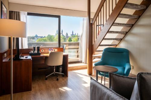 an office with a desk and chair and a window at Crowne Plaza Maastricht by IHG in Maastricht