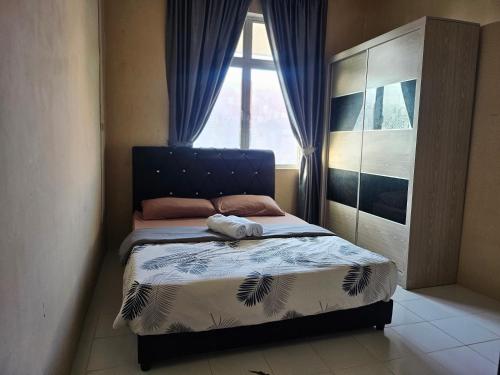 a small bedroom with a bed with a window at Hadi's Homestay in Sandakan