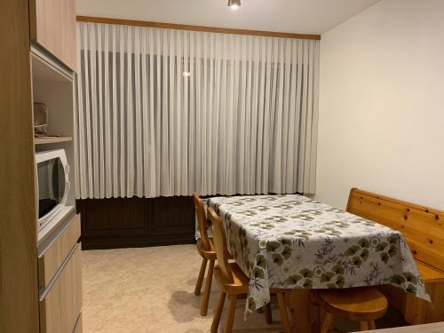 a dining room with a table and a television at Appt de montagne Araches in Arâches-la-Frasse