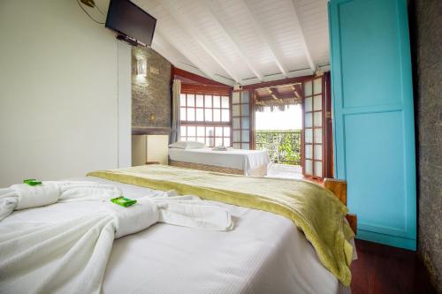 Katil atau katil-katil dalam bilik di VELINN Pousada Guarubela Villa Vittoria