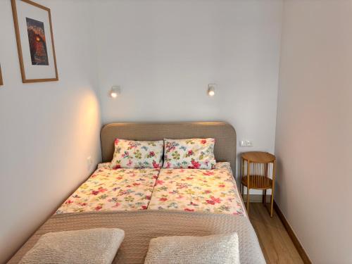 a small bedroom with a bed with a flower blanket at Nadmorski Relaks - komfortowy apartament blisko plaży w Sunset Resort in Grzybowo