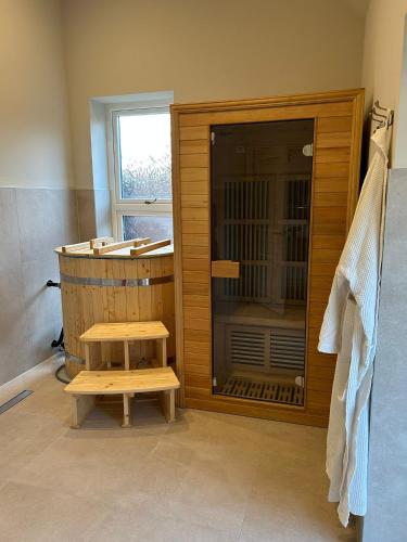 a bathroom with a shower and a bench next to a tub at Goring River Retreat with Gym and Wellness Area in Goring