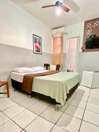 a bedroom with a bed and a ceiling fan at Hotel Avenida Bauru in Bauru