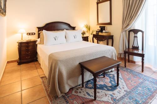 a bedroom with a bed and a table and a mirror at Hotel Palacio de Hemingway in Ronda