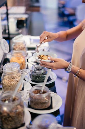 a group of people holding plates of food on a table at Hotel Colombo in Lido di Jesolo