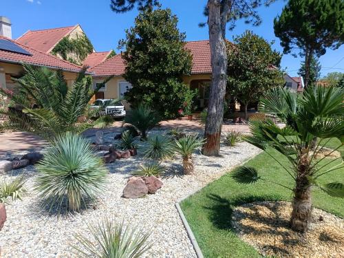 a garden in front of a house with plants at Spengler Apartman in Harkány