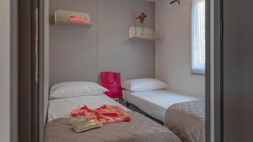 a small room with two beds and a window at Camping Grande Italia in Chioggia