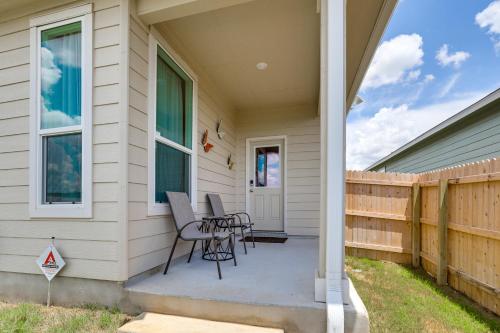 a porch of a house with two chairs and a table at 12 Mi to San Antonio River Walk Home with Yard! in Elmendorf