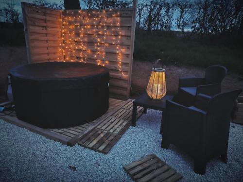a room with a tub and a chair and a table at Lodge romantique "le grand chêne" avec Jacuzzi privatif in Lapalisse