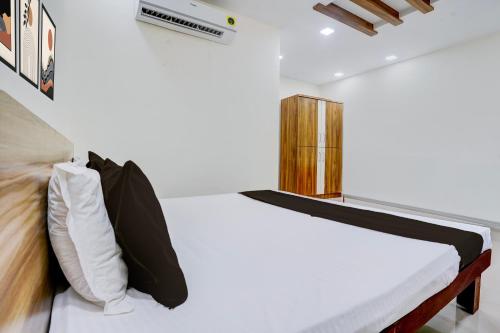 a bedroom with a bed with white sheets and pillows at Hotel O Shree Prabhat in Mumbai