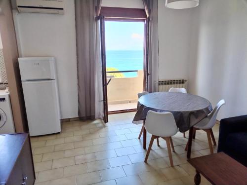 a kitchen with a table and chairs and a window at Poseidon Bay Residence in Milazzo