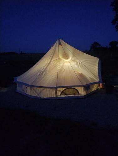 a tent that is lit up at night at Lodge romantique "le grand chêne" avec Jacuzzi privatif in Lapalisse