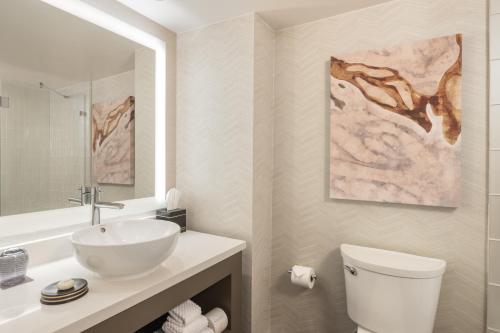 a white bathroom with a sink and a toilet at The San Luis Resort Spa & Conference Center in Galveston