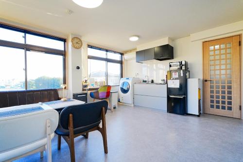 a kitchen with a refrigerator and a table and chairs at Saitama Kyodo Building - Vacation STAY 02388v in Saitama