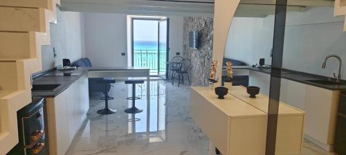cocina con encimeras negras y vistas al océano en Giudecca Suite Sea View, en Cefalú