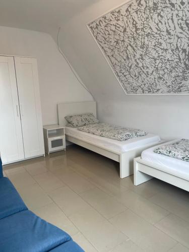 a room with two beds and a ceiling at Hotel Shelby Apartments in Garbsen
