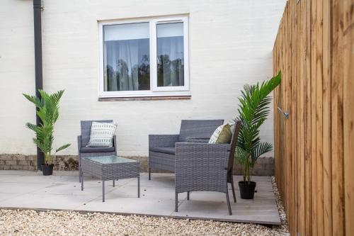 a patio with chairs and a table and a window at Vacant Nest The South End Spacious Smart Tv in Kielder