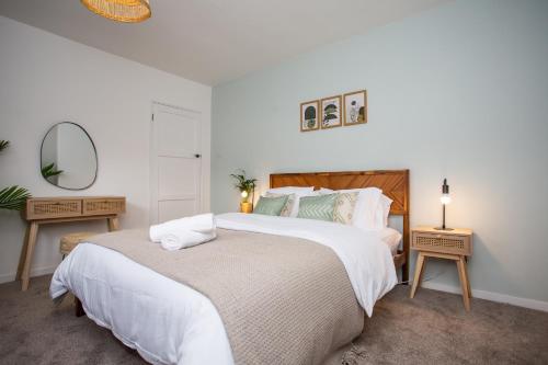 a white bedroom with two beds and a mirror at Vacant Nest The South End Spacious Smart Tv in Kielder