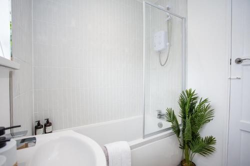 a white bathroom with a sink and a shower at Vacant Nest The South End Spacious Smart Tv in Kielder
