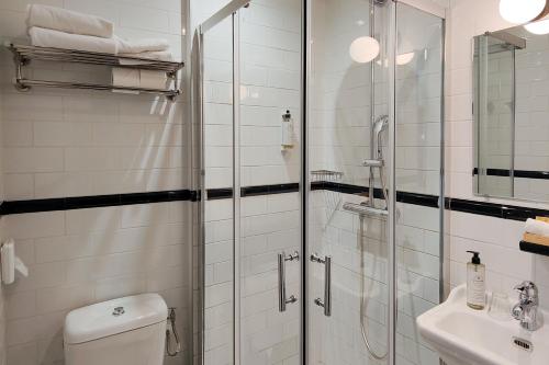 a bathroom with a shower and a toilet and a sink at Hôtel de France, un hôtel AMMI in Nice