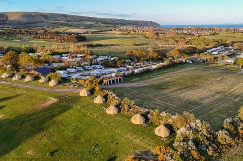an aerial view of a village with tents in a field at Herston Caravan & Camping in Swanage