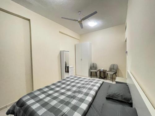 a bedroom with a bed and two chairs in it at Spacious Fully Furnished Master Room in Ajman 
