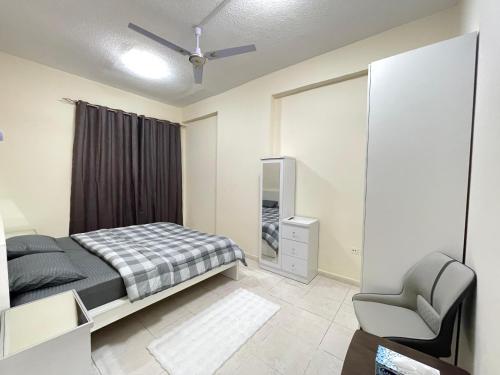 a bedroom with a bed and a ceiling fan at Spacious Fully Furnished Master Room in Ajman 