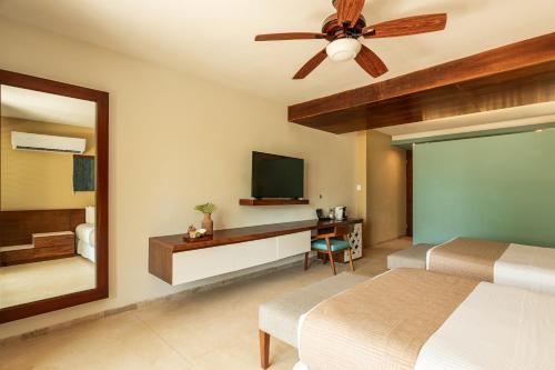 a bedroom with two beds and a ceiling fan at Villas Caracol in Holbox Island