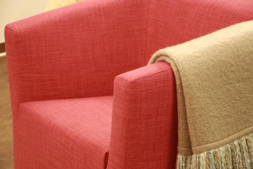 a red couch with a blanket on the back of it at Mr.& Mrs. President in Erfurt