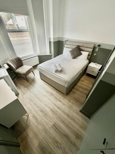 a small bedroom with a bed and a chair at The Goldsmith Residence - 43 - Prime Locaton Rooms in London