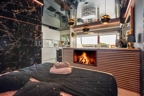 un salon avec une cheminée et un lit dans l'établissement Bacarrat coursive Port nature, au Cap d'Agde
