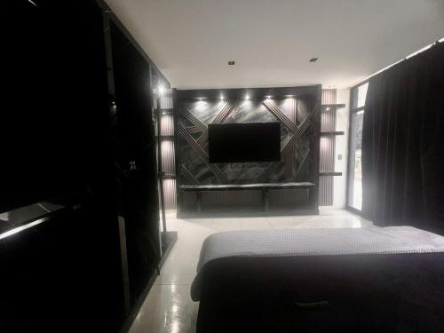 a bedroom with a bed and a tv on a wall at Hotel Gool de Guerrón in Quito