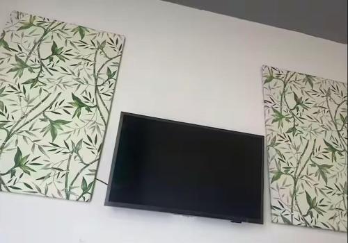 a flat screen tv on a wall next to two mirrors at Apartamento Aconchegante prox Aeoroporto in Manaus
