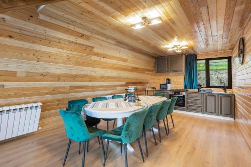 a kitchen and dining room with a table and chairs at NordiKaban A-Frame Vatra Dornei in Ortoaia