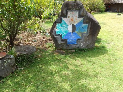 a rock with a painting on it in the grass at Marambu Pukyu in Ibarra