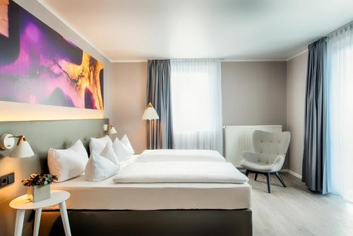 オッフェンバッハにあるOffenbach Plaza Hotelのベッドと椅子のあるホテルの部屋