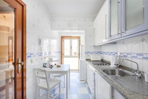 a white kitchen with a sink and a counter at Top Floor Retreat in Espinho in Espinho