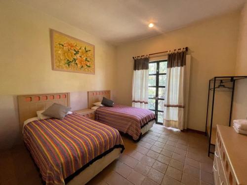 a hotel room with two beds and a window at Hotel Casa San Pablo in Oaxaca City
