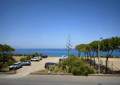 a bunch of cars parked in a parking lot near the ocean at Poseidon Bay Residence in Milazzo