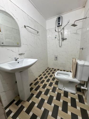 een witte badkamer met een wastafel en een toilet bij Nimsara Holiday Resort in Anuradhapura